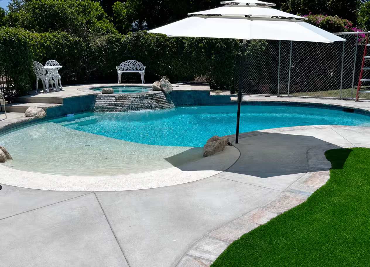 Freeform pool with beach entry and raised spa