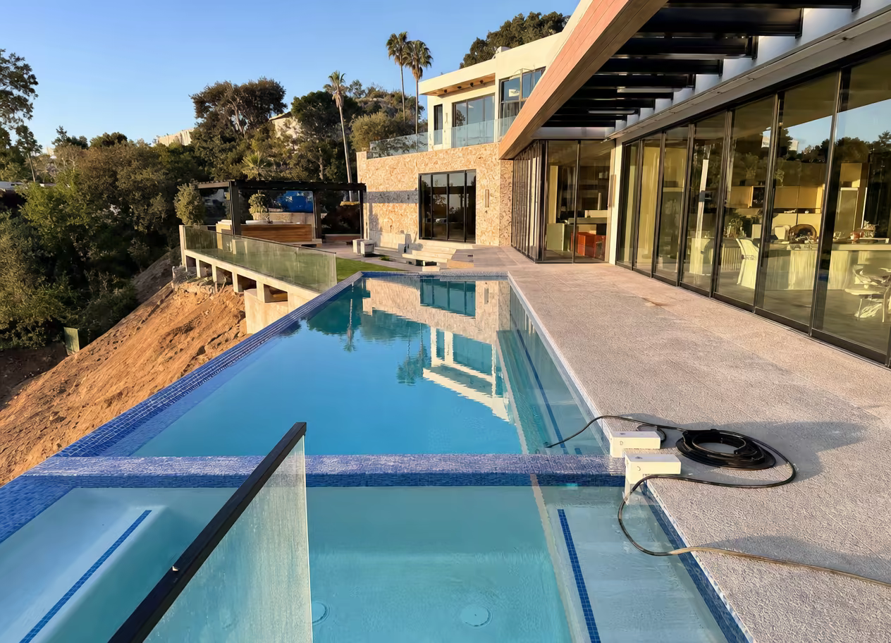Modern glass-edge pool beside a contemporary home